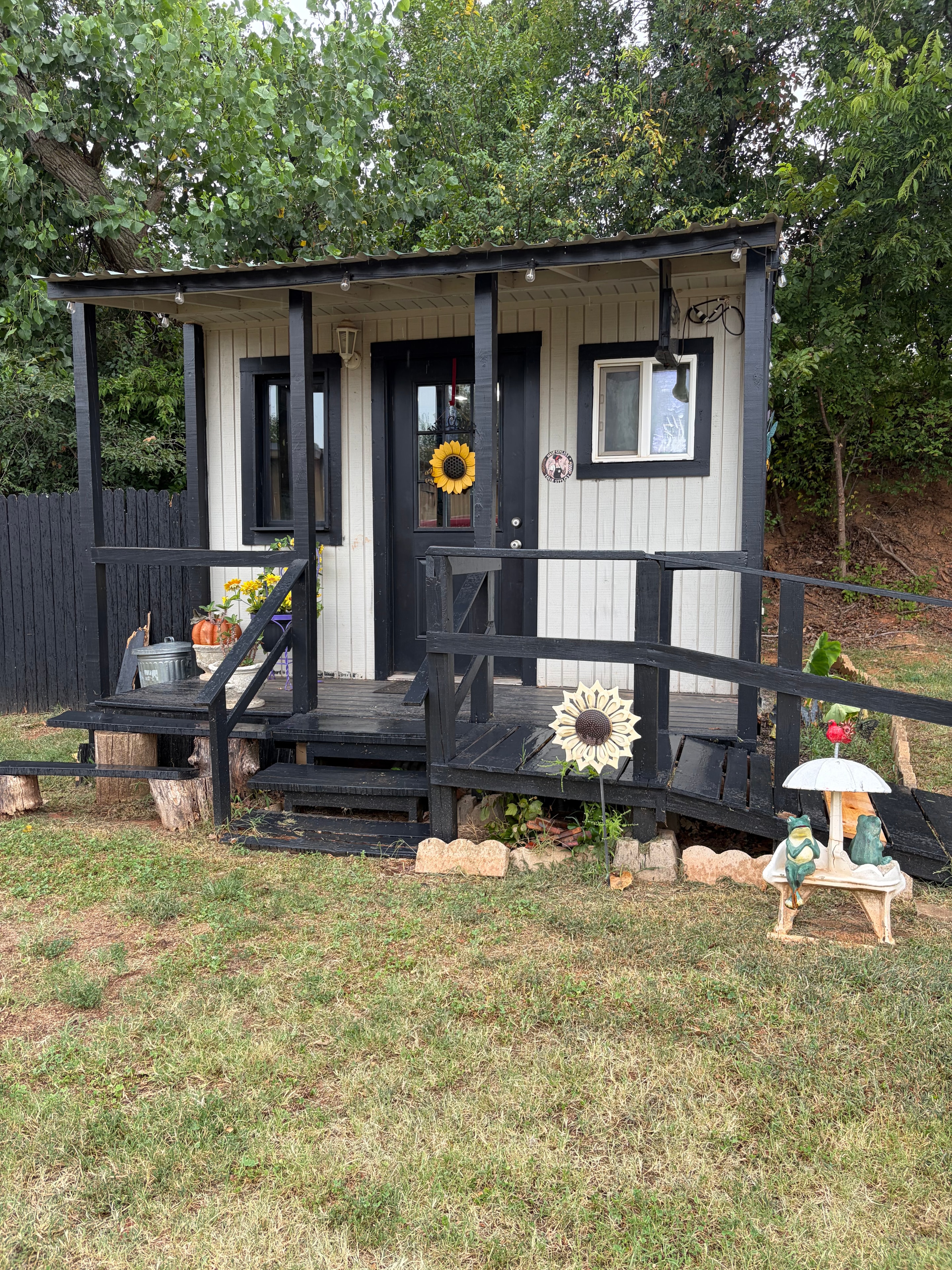 Cabin exterior with black trim, sunflower décor, and covered porch