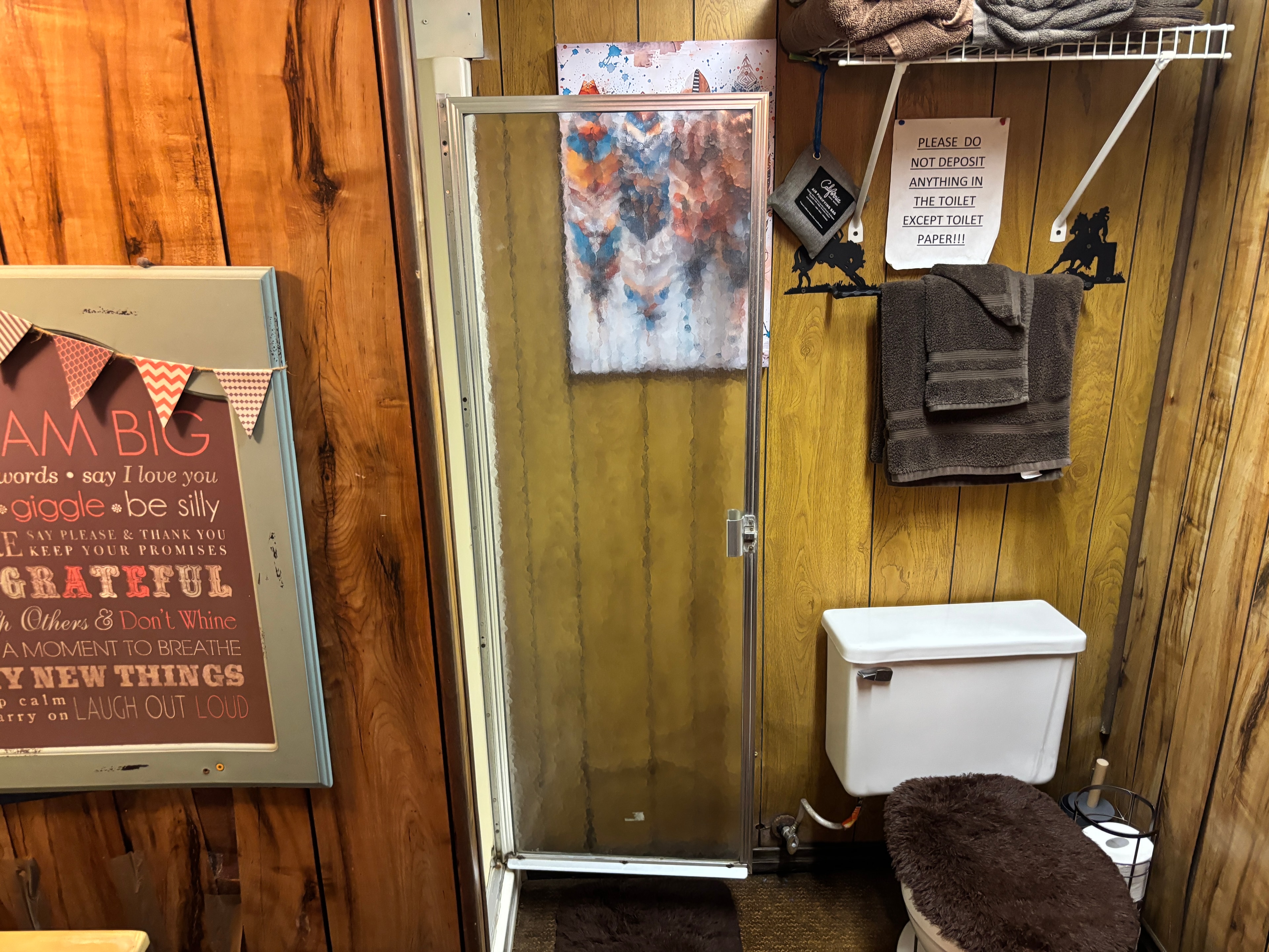 Hallway with horse artwork, restroom sign, and western décor